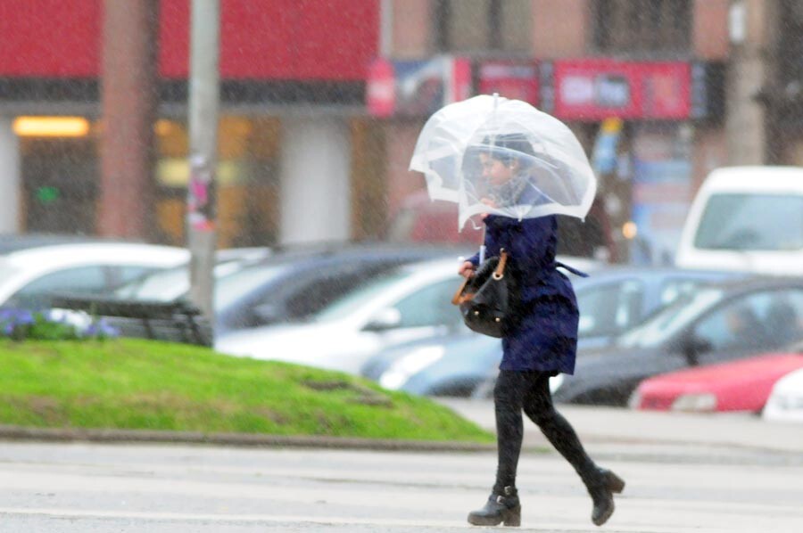 Una mujer camina con paraguas en Plaza Independencia un día de lluvia en Montevideo.