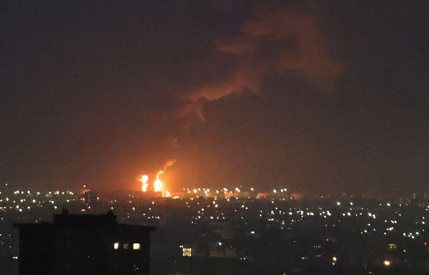 Las llamas de un incendio en la refinería de petróleo de Teherán, ubicada al sur de la capital, se ven ardiendo a lo lejos el 15 de junio de 2025.