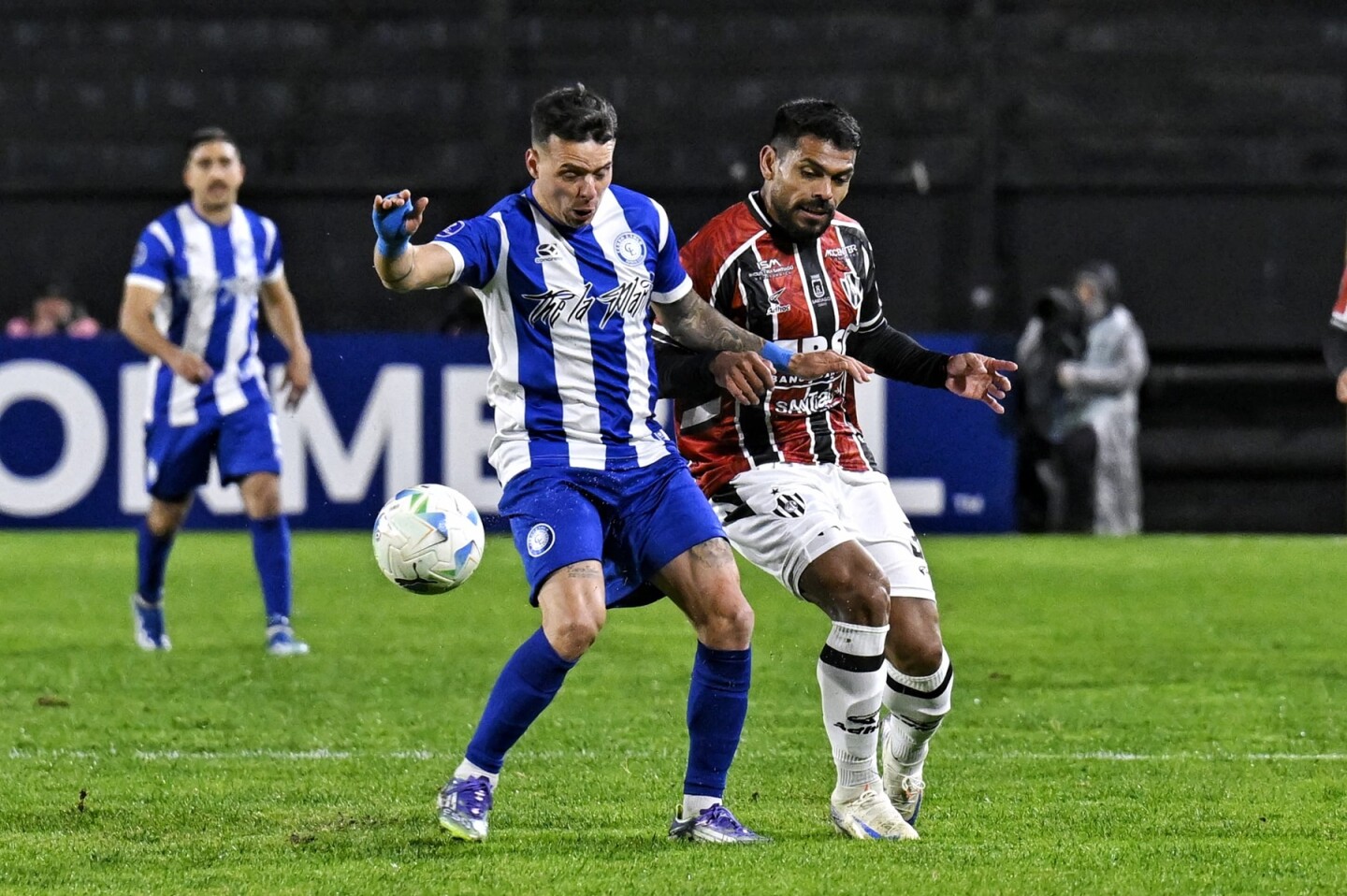 Leandro Otormín busca la pelota ante la marca de Santiago Moyano en el partido entre Cerro Largo y Central Córdoba.