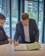 Darío Werthein firma el acuerdo con Rajeev Badyal y Panos Panay.