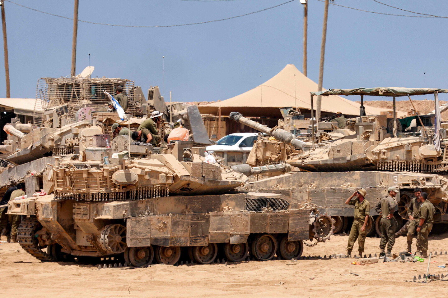 Soldados del ejército israelí realizan tareas de mantenimiento en un tanque de batalla principal situado cerca de la frontera con la Franja de Gaza.