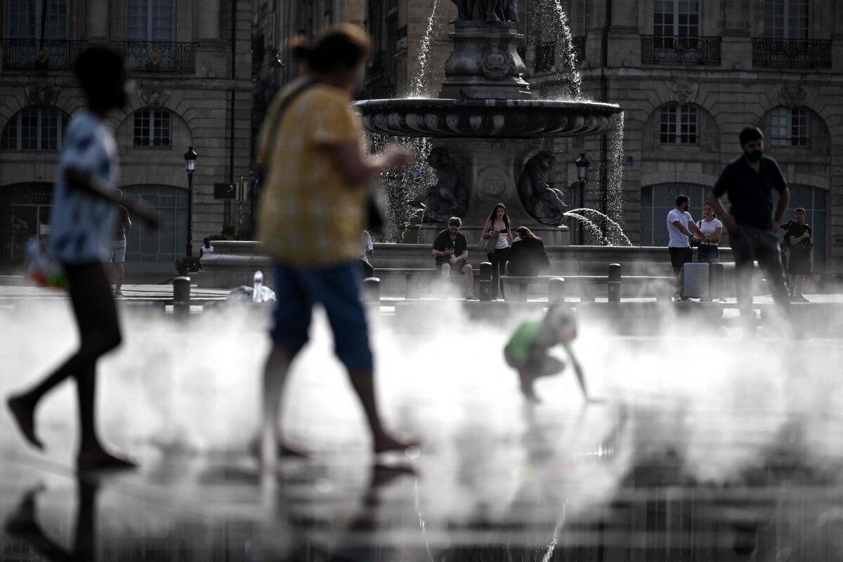 Peatones caminan por el estanque reflectante en medio de una ola de calor que afecta a Europa.