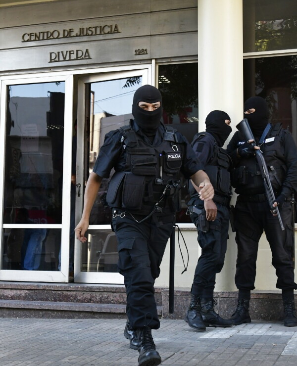 Policías con pasamontañas trabajan en la puerta