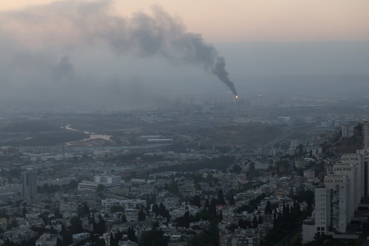 Se elevan columnas de humo desde un lugar alcanzado durante los ataques con misiles iraníes en la ciudad de Haifa la madrugada del 16 de junio de 2025.