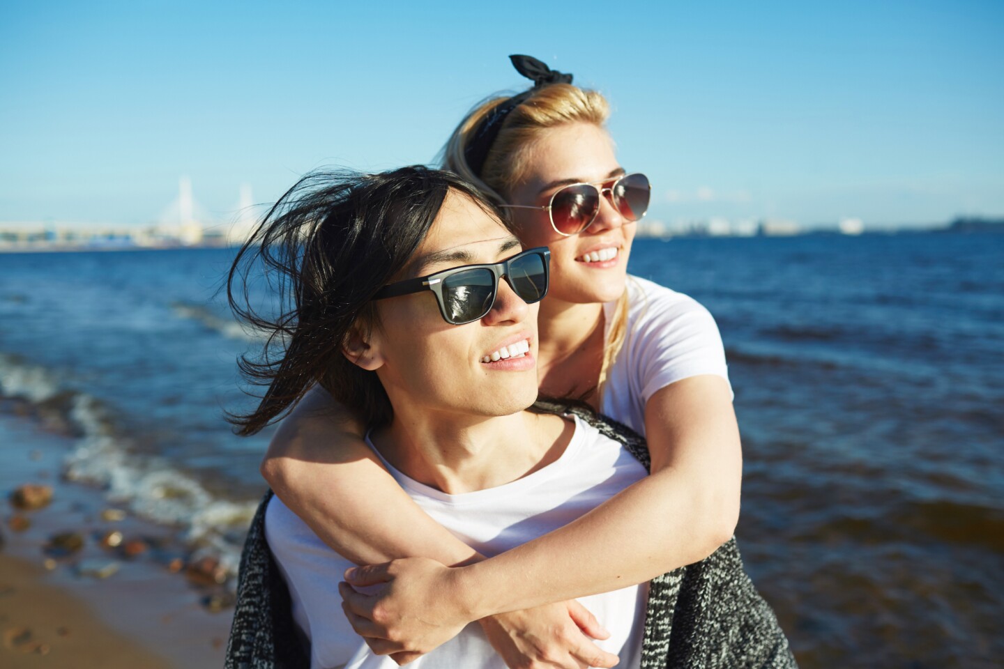 Madre e hija con lentes de sol en la playa