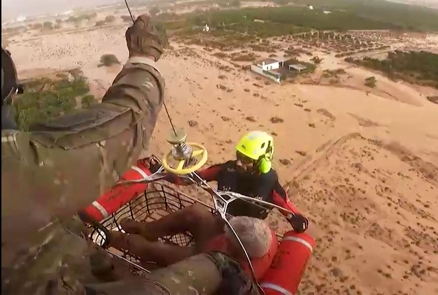 Esta captura de vídeo muestra a los rescatistas españoles llevando a un hombre suspendido en el aire sobre una plataforma.