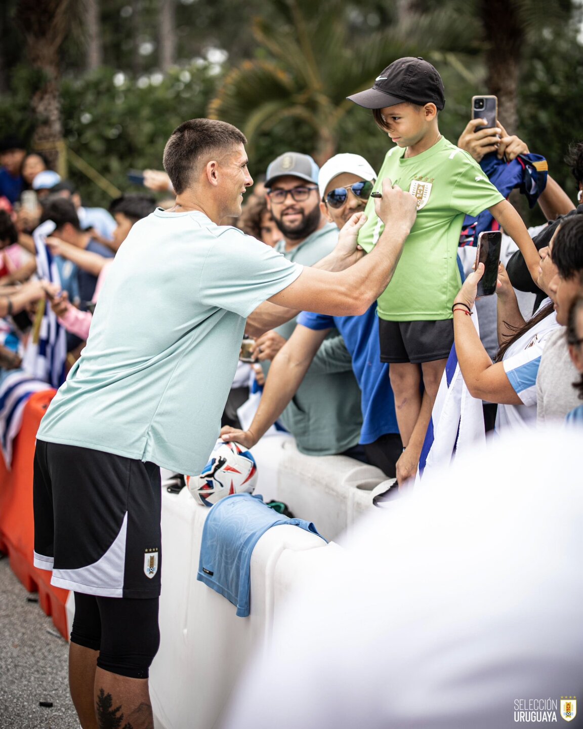 Sergio Rochet firma la camiseta de un niño durante un entrenamiento de Uruguay en la Copa América 2024.