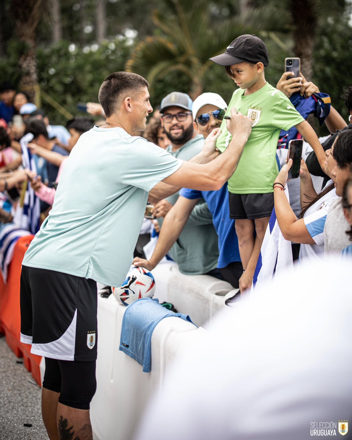 Sergio Rochet firma la camiseta de un niño durante un entrenamiento de Uruguay en la Copa América 2024. 