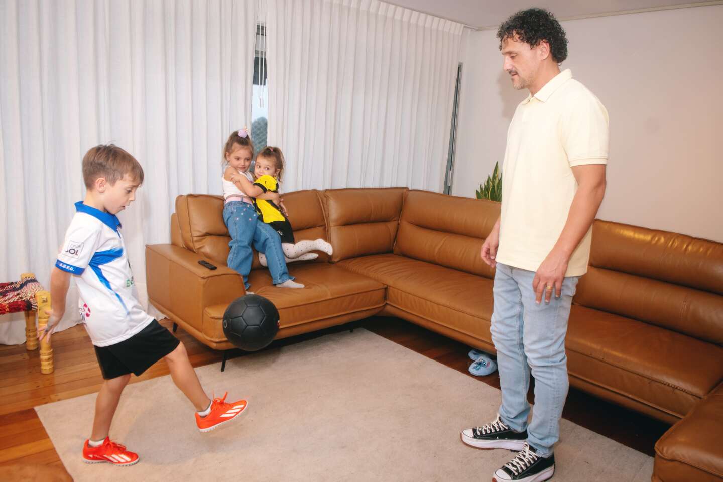 Matías Aguirregaray jugando a la pelota con sus hijos.