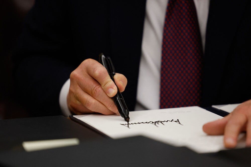 Donald Trump firma una orden ejecutiva en el Salón Oval de la Casa Blanca.