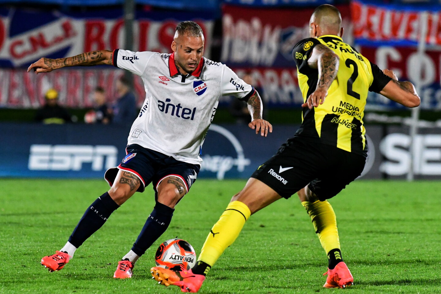 Nicolás López ante Leo Coelho en el clásico entre Nacional y Peñarol.