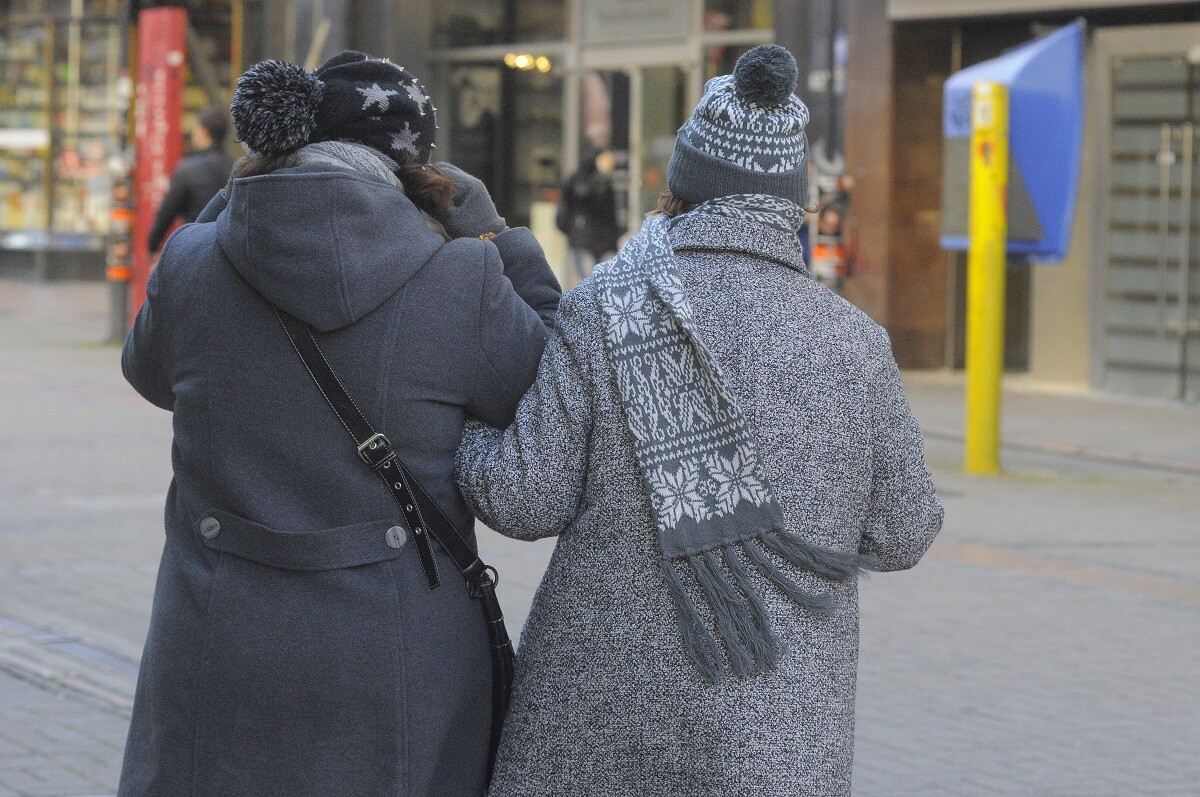 Dos mujeres caminan abrigadas por Ciudad Vieja un día de frío en Montevideo.
