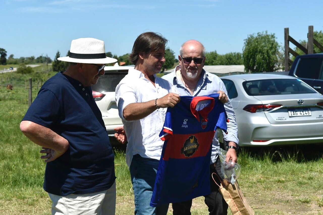 El presidente Luis Lacalle Pou sostiene la camiseta del club San Bautista Vida Nueva que le obsequiaron.