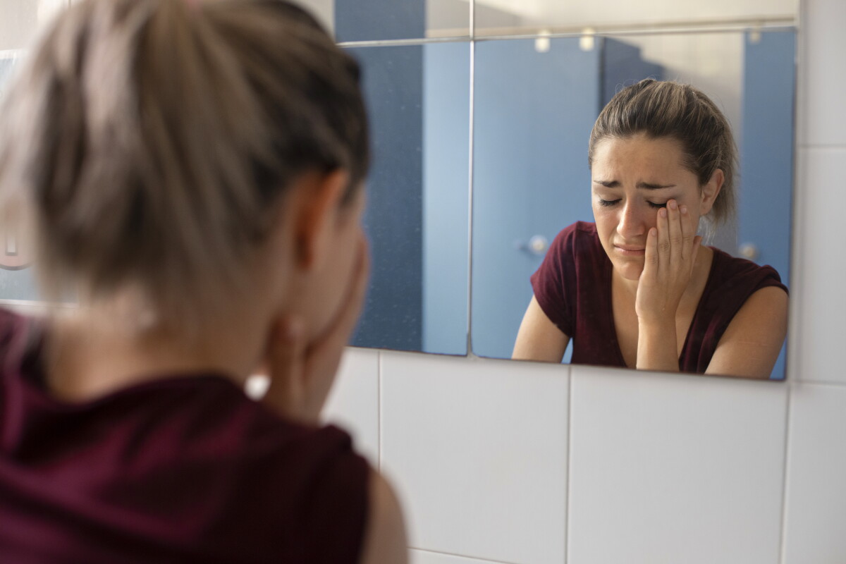 Mujer llorando frente a un espejo