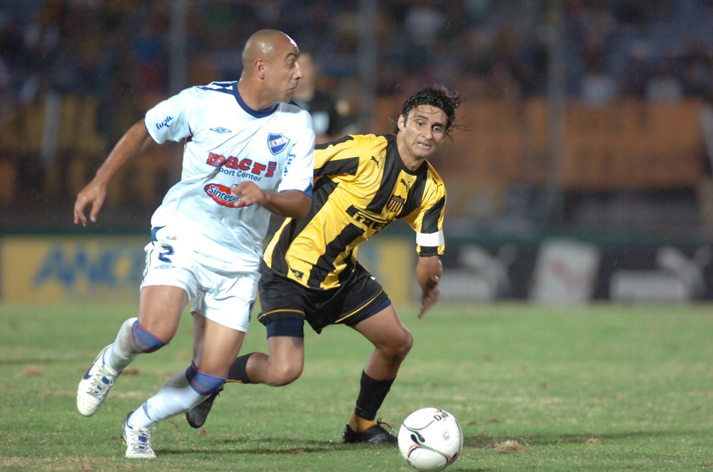Pablo Melo lleva la pelota ante la marca de Carlos Bueno en un clásico entre Nacional y Peñarol.