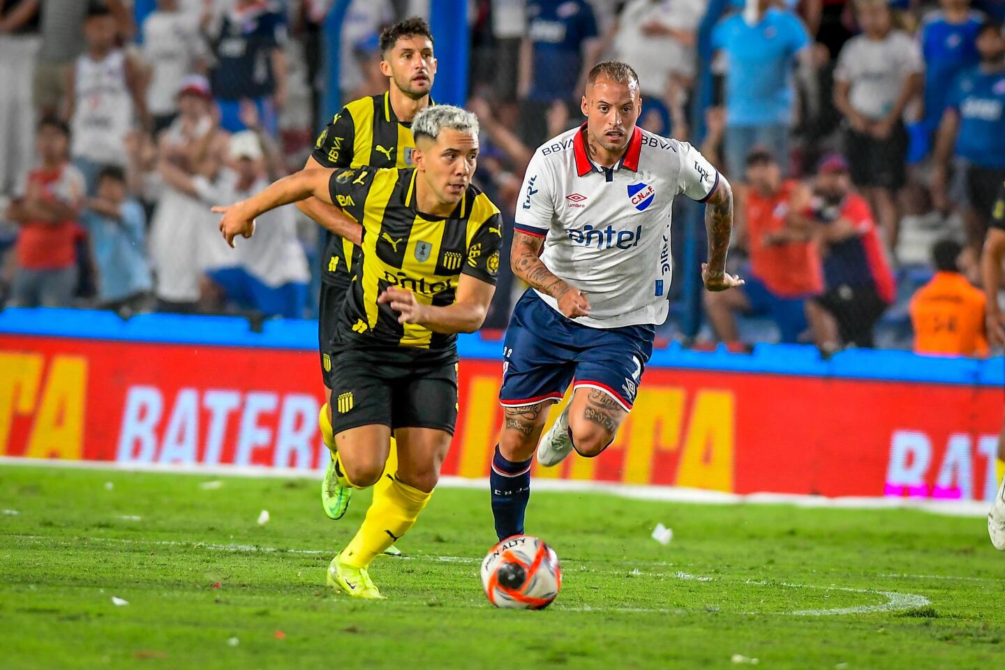 Leo Fernández traslada la pelota ante la marca del Diente López en el clásico Nacional vs. Peñarol.