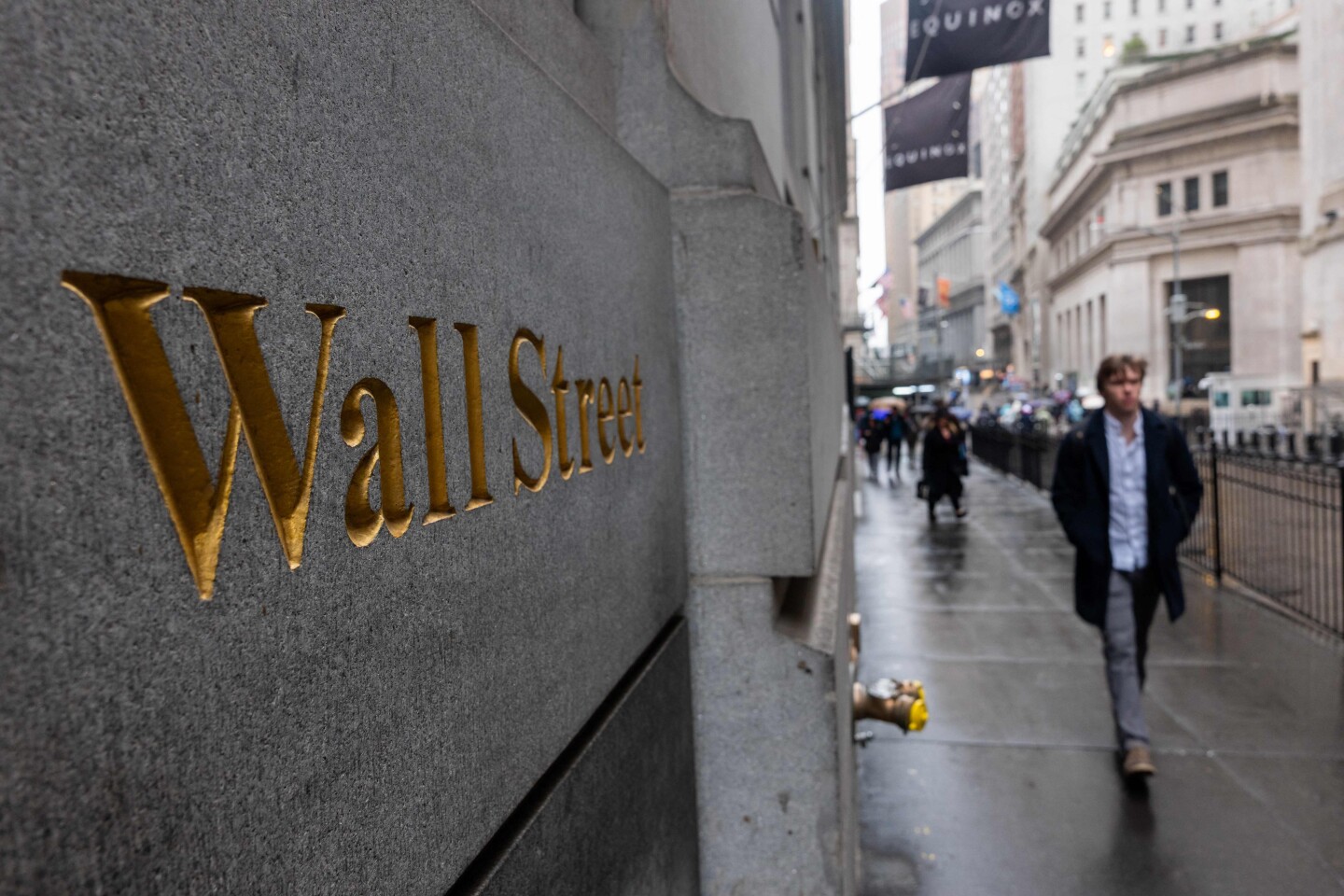 Nueva York: la gente camina por Wall Street mientras los mercados de todo el mundo volvieron a caer