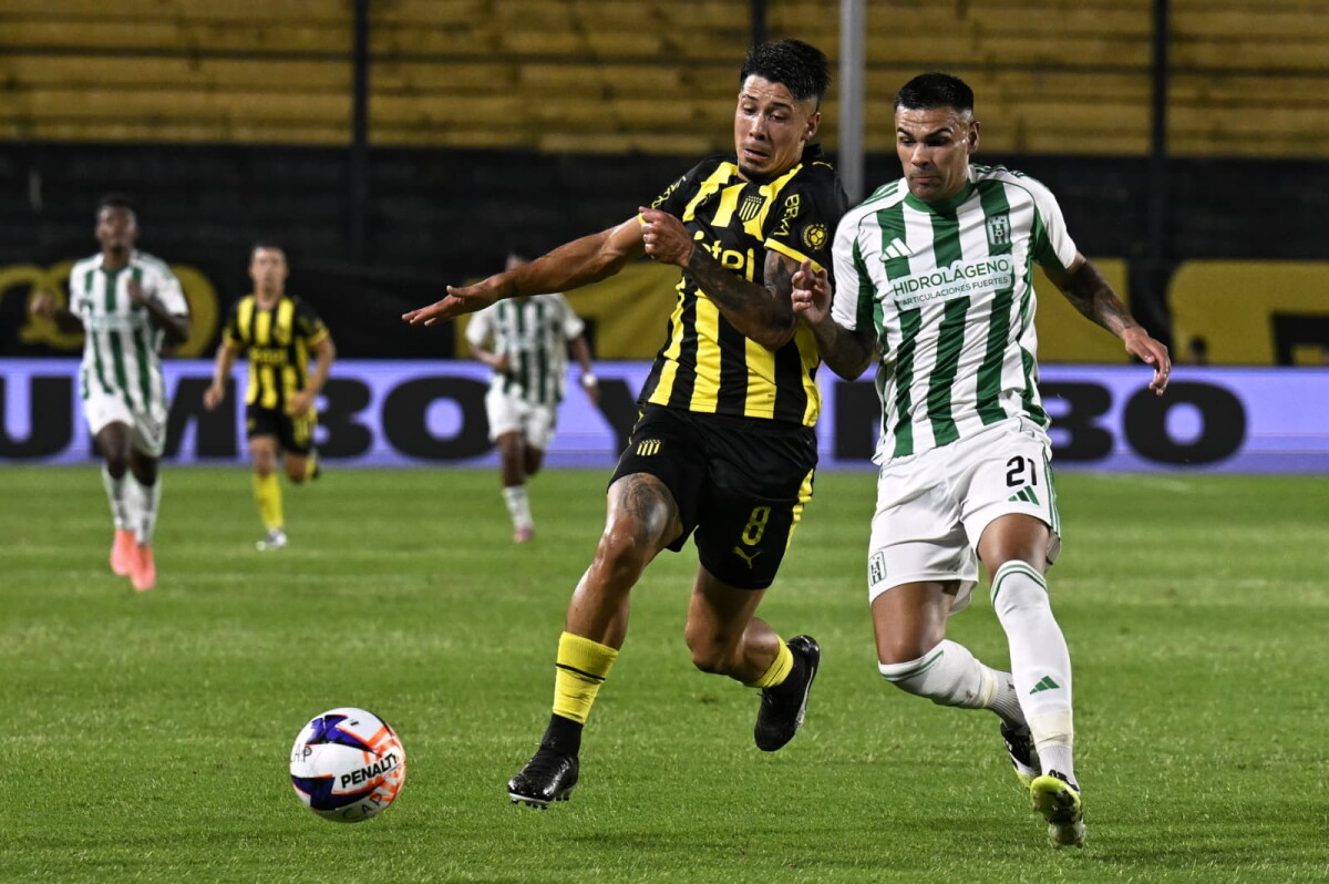 Nicolás Fernández y Agustín Álvarez Wallace disputan la pelota en el partido entre Peñarol y Racing.