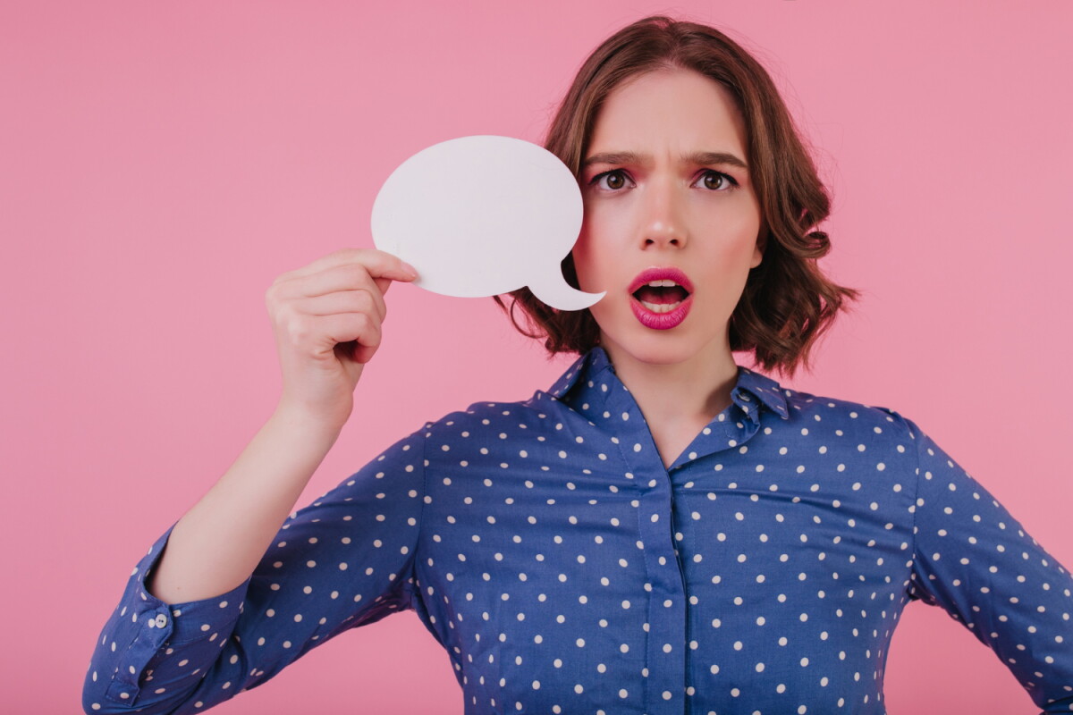 Mujer sostiene un globo de conversación.