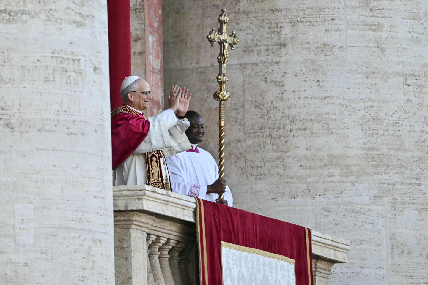 El recién elegido Papa León XIV, Robert Francis Prevost (izq.), hace un gesto en el balcón central de la logia de la Basílica de San Pedro.