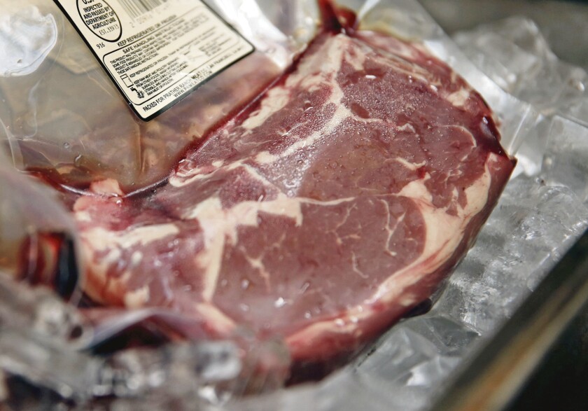 Individual packages of steak are shown with labels at a meat shop in San Francisco