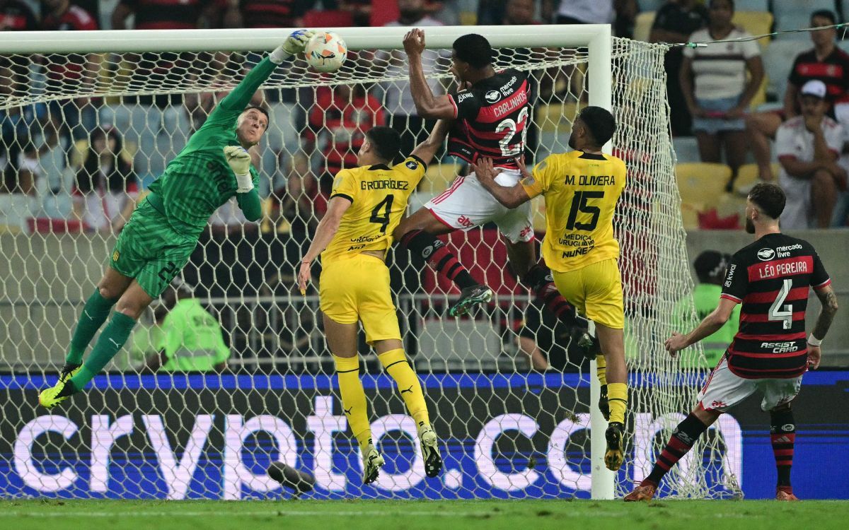 Washington Aguerre y una de sus atajadas en el partido entre Flamengo y Peñarol.