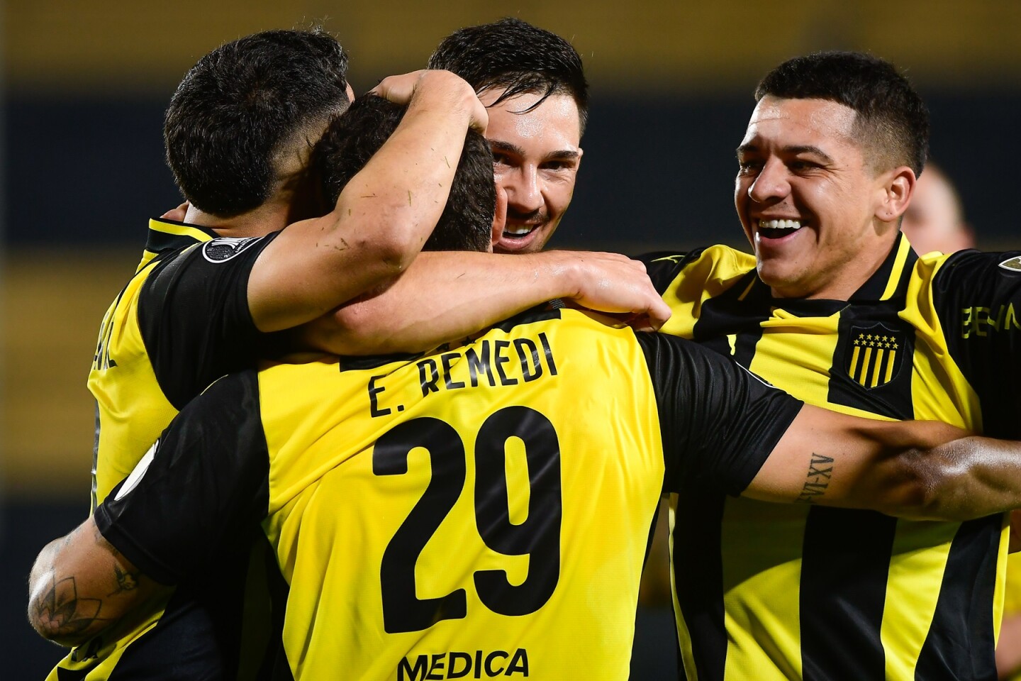 Eric Remedi se abraza con Maximiliano Silvera y Diego García.