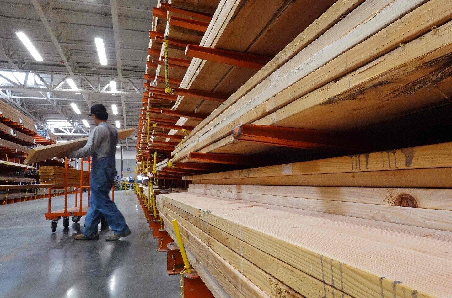 Un cliente selecciona un trozo de madera de la sección de madera de Home Depot en California.