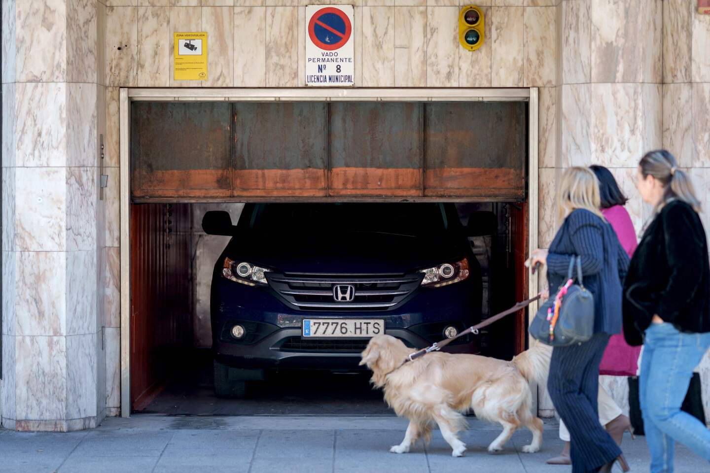 Peatones pasan junto a un coche atascado en un garaje en Burgos durante un corte de electricidad masivo.