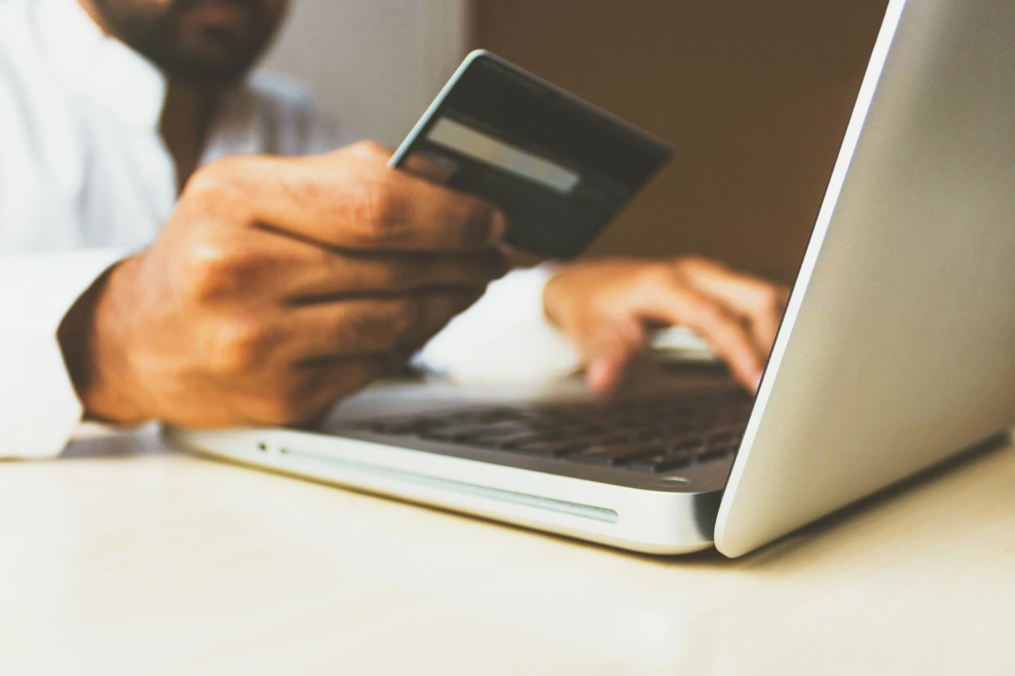 Hombre usando su tarjeta de crédito ante una compra online